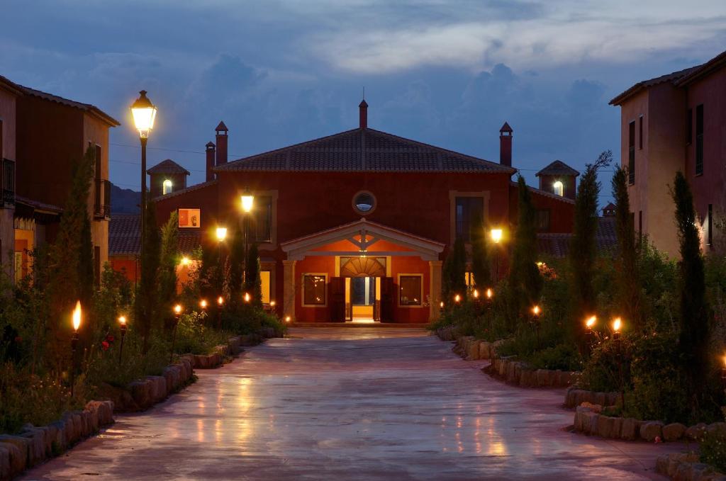 a house with a pathway leading to a building with lights at Hotel San Miguel del Valle Amblés in El Fresno