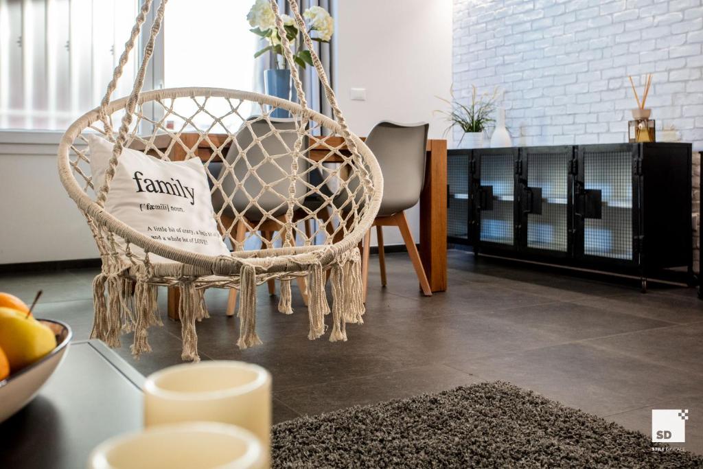 a room with a rattan chair and a table at Pam Style Home in Bologna
