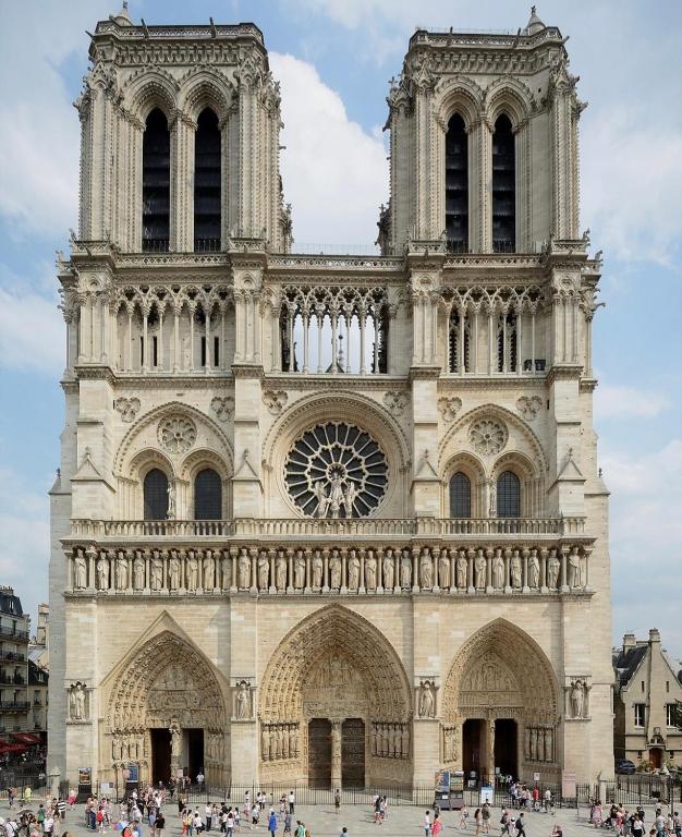 Une grande cathédrale avec des personnes debout devant elle dans l'établissement Bel appartement au cœur de paris, à Paris