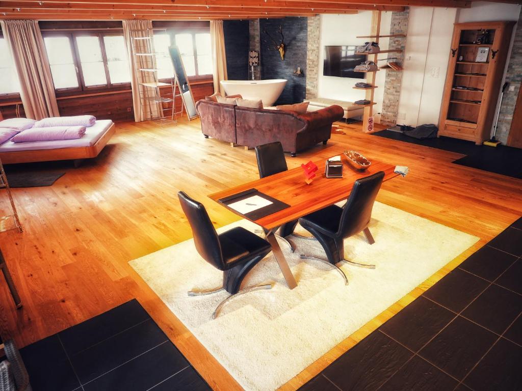 Haus Rhätikon Mayer في دافوس: غرفة معيشة مع طاولة وكراسي خشبية