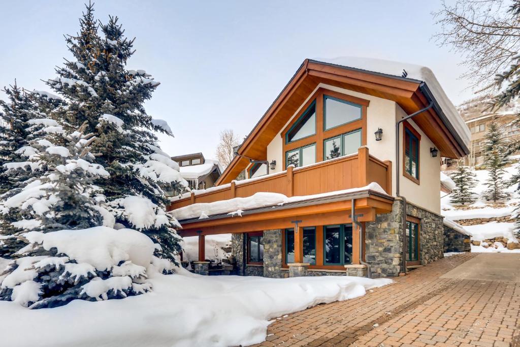 une maison dans la neige avec un arbre dans l'établissement Mountain Flower, à Vail