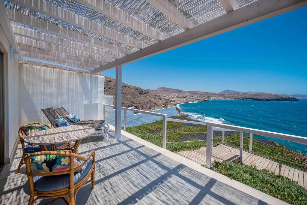 a balcony with a table and chairs and the ocean at Etti-Paradise Suite La Ballena in Pájara