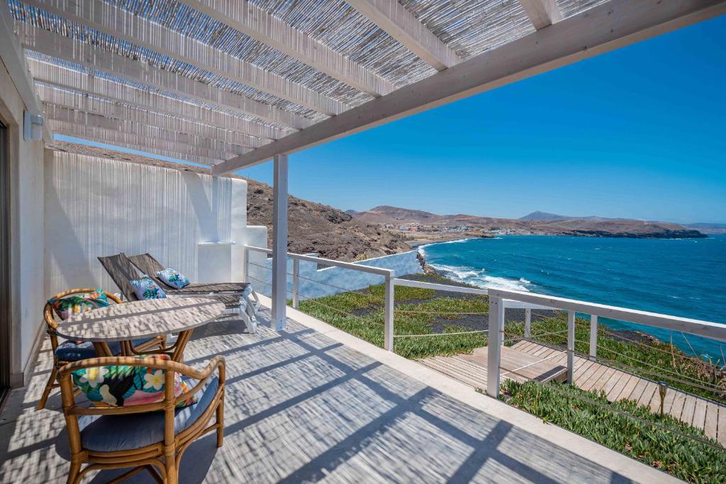 a balcony with a table and chairs and the ocean at Etti-Paradise Suite La Ballena in Pájara