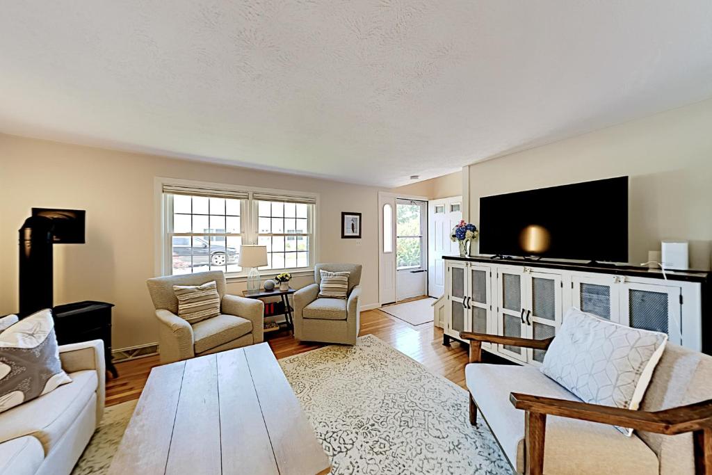 a living room with a couch and a table at Harborside Retreat in Falmouth