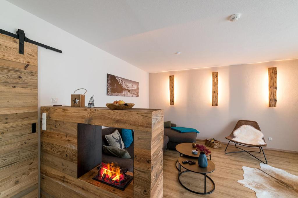 a living room with a fireplace and a couch at Alpen-Lounge Apartment 17 in Fügen