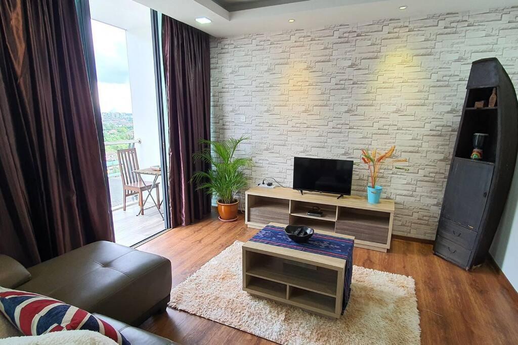 Vivacity Jazz Suites 2 New Cozy Home LV8 في كوتشينغ: غرفة معيشة مع أريكة وتلفزيون على طاولة