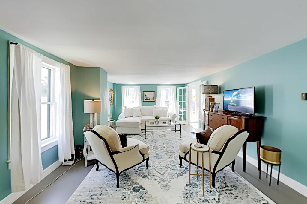 una sala de estar con paredes azules y muebles blancos. en Wiscasset Holiday, en Wiscasset