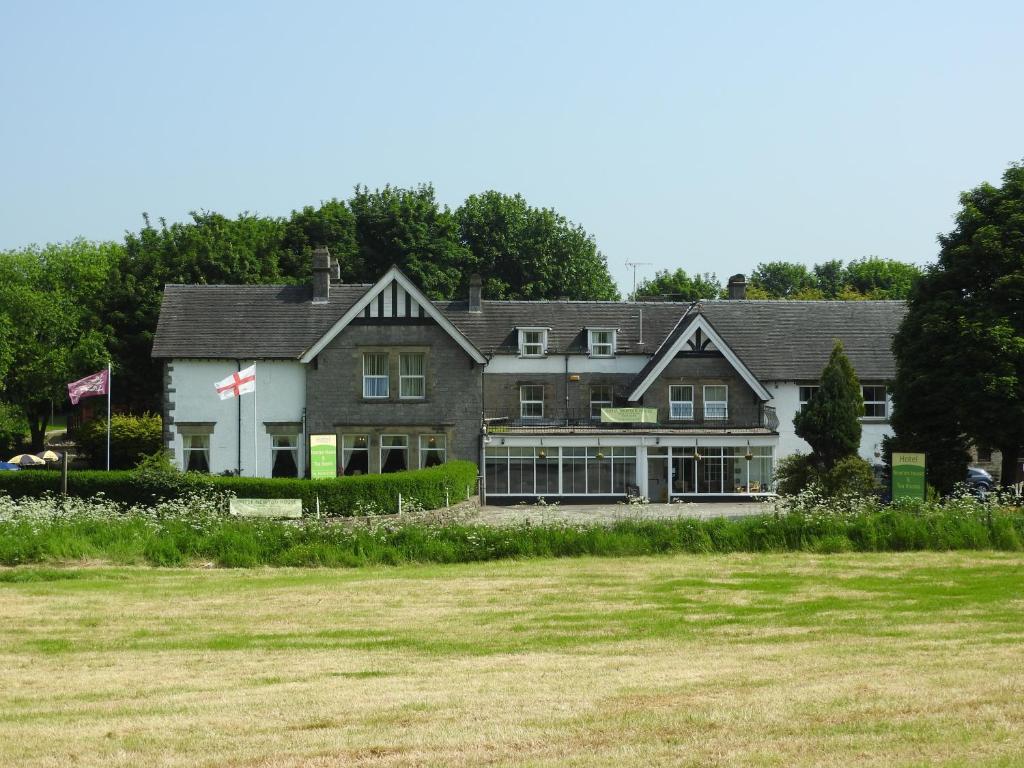 una grande casa con un prato davanti di Newton House ad Alstonfield