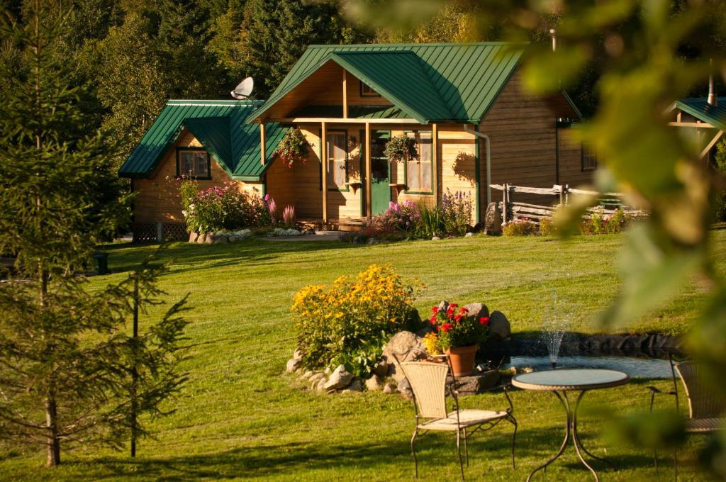 una casa con un tavolo e sedie di fronte di Chalet Paradis de Charlevoix a Baie-Saint-Paul