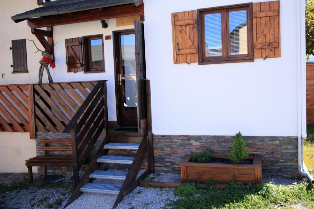 una casa con una escalera de madera que conduce a la puerta principal en Chalet CAL CAPOU, en Bolquere Pyrenees 2000
