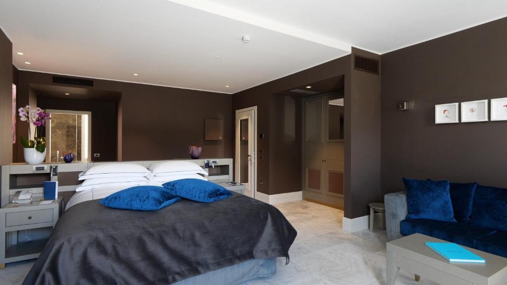 a bedroom with a bed with blue pillows on it at Palazzo Doglio in Cagliari