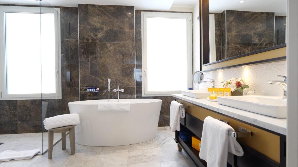 a bathroom with a large tub and two sinks at Palazzo Doglio in Cagliari