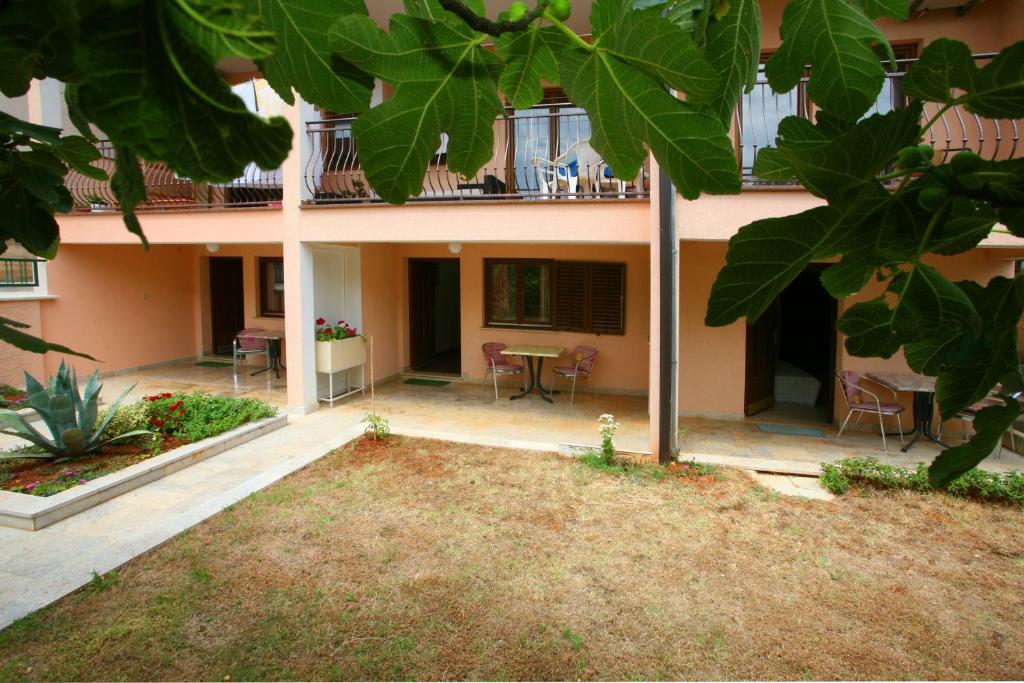 a courtyard of a building with a table and chairs at Apartments Neda - Poreč South in Poreč