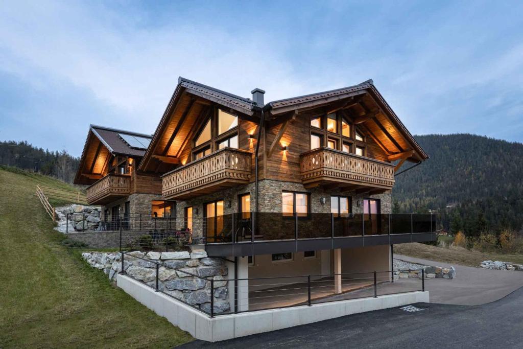 een groot houten huis bovenop een heuvel bij Ferienlodge Edelstein in Forstau