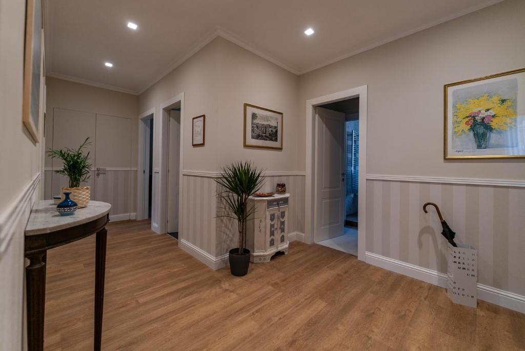 een grote kamer met een hal met een tafel en planten bij Nuances The Colosseum Apartment in Rome