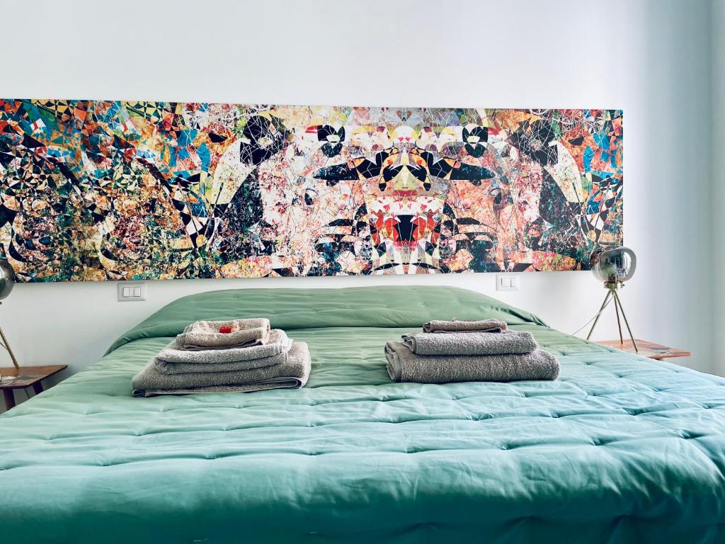 ein Schlafzimmer mit einem grünen Bett und Handtüchern darauf in der Unterkunft chiesa russa in Bari