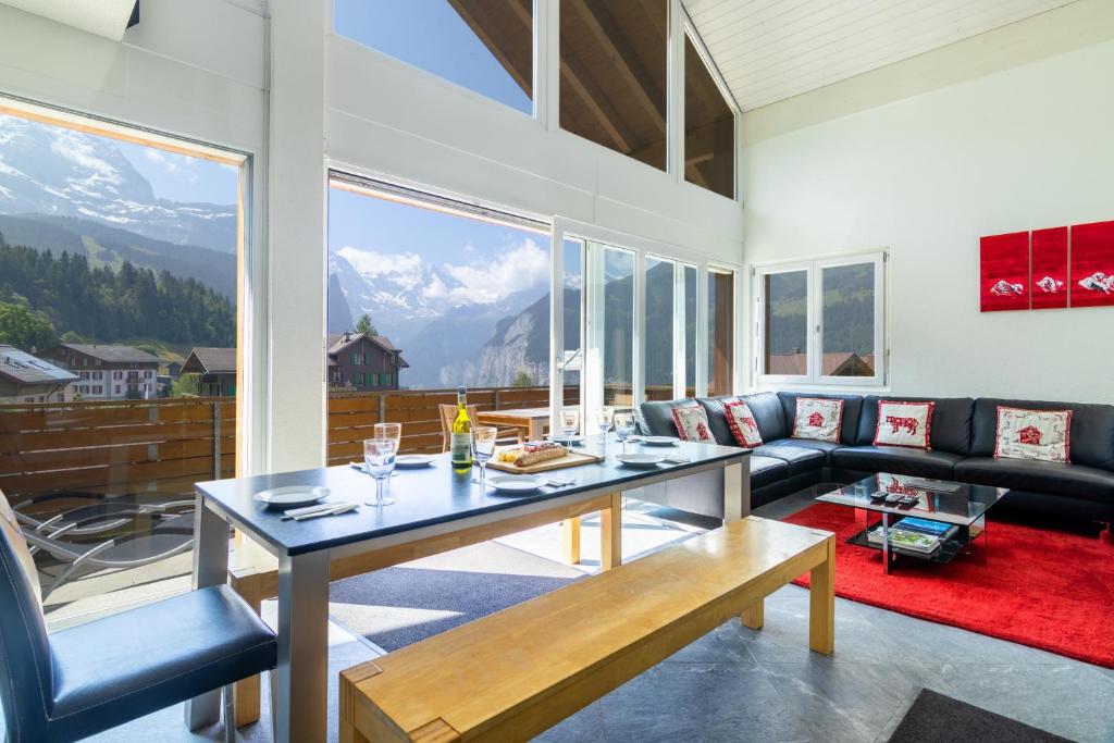 sala de estar con mesa y sofá en Chalet Hannegg Penthouse en Wengen