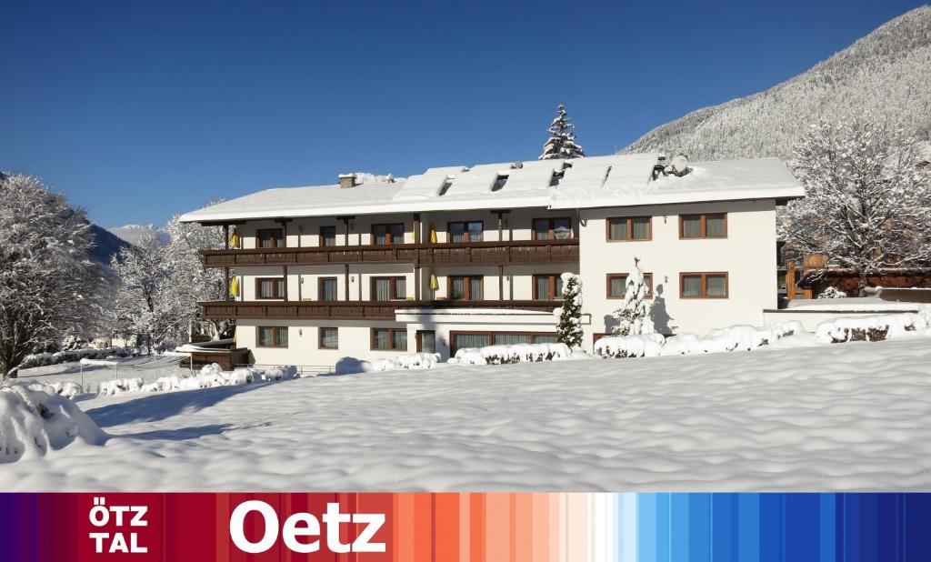 a building with snow on the ground in front of it at Haus Marita in Oetz