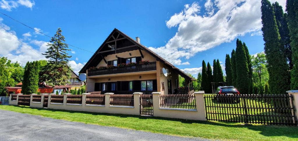 a house with a fence in front of it at Varga Gardens Balatonmáriafürdő in Balatonmáriafürdő
