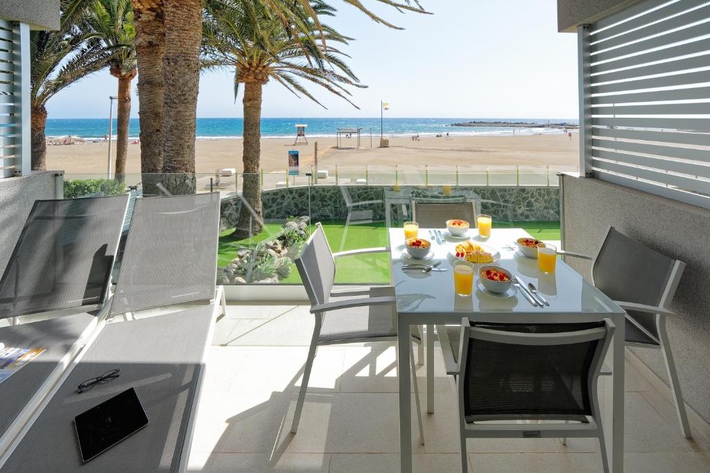 een eettafel met stoelen en uitzicht op het strand bij ConMar in San Agustin