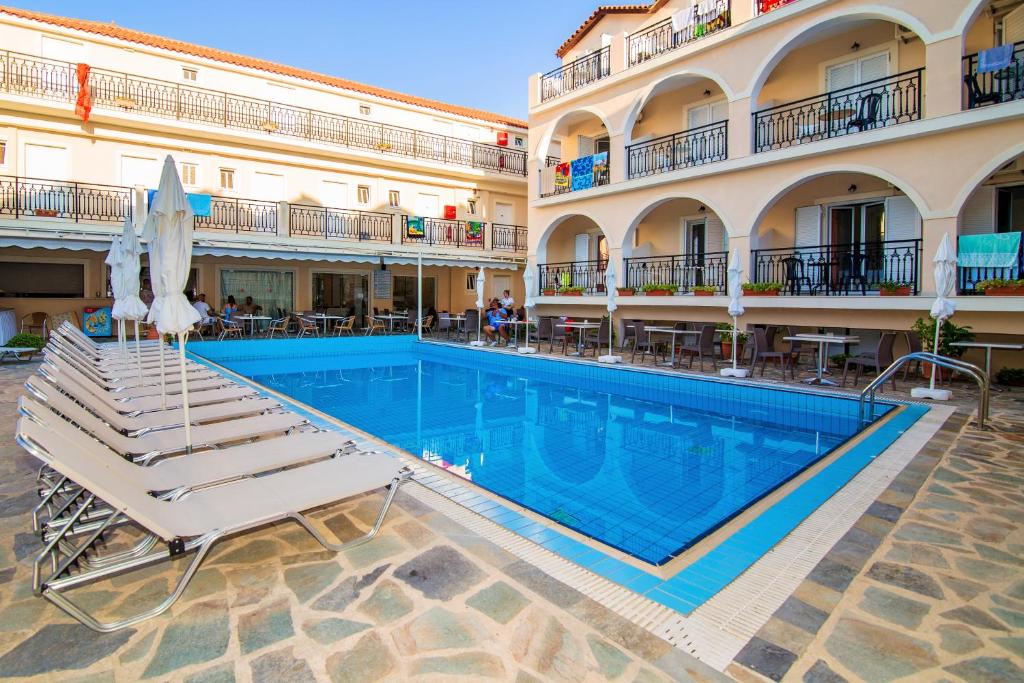 a swimming pool in a hotel with lounge chairs at Playa Bay Hotel Zakynthos in Laganas