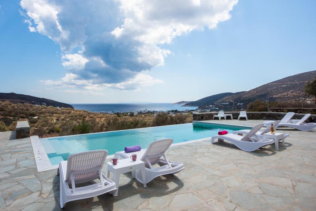 Villa con piscina con sillas y vistas. en Ktima Vrisiana, en Platis Yialos Sifnos
