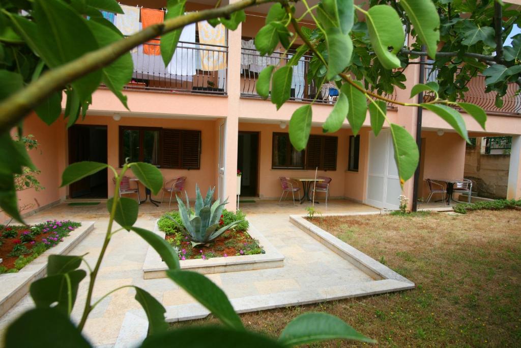 a courtyard of a building with chairs and a plant at Apartments Neda - Poreč South in Poreč