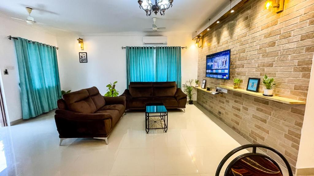 a living room with two couches and a flat screen tv at Beach Retreat Villa in Varca