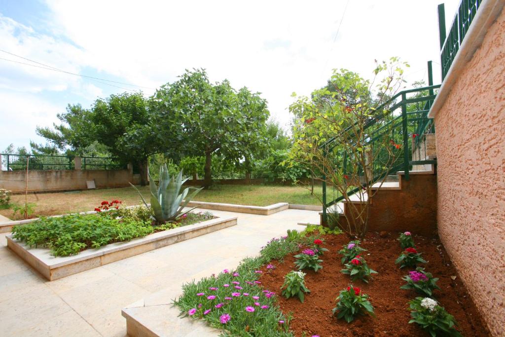a garden with flowers and a staircase in a building at Apartments Neda - Poreč South in Poreč