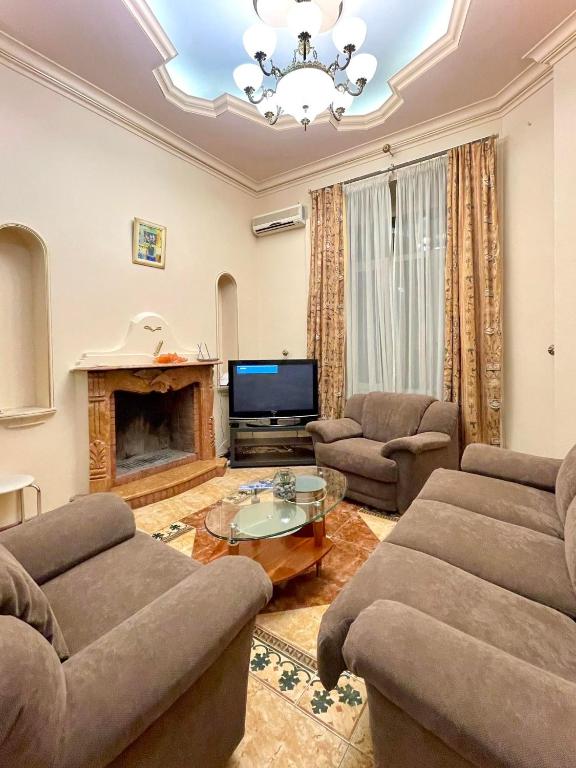 uma sala de estar com dois sofás e uma televisão em Great one Bed right near Opera House em Kiev