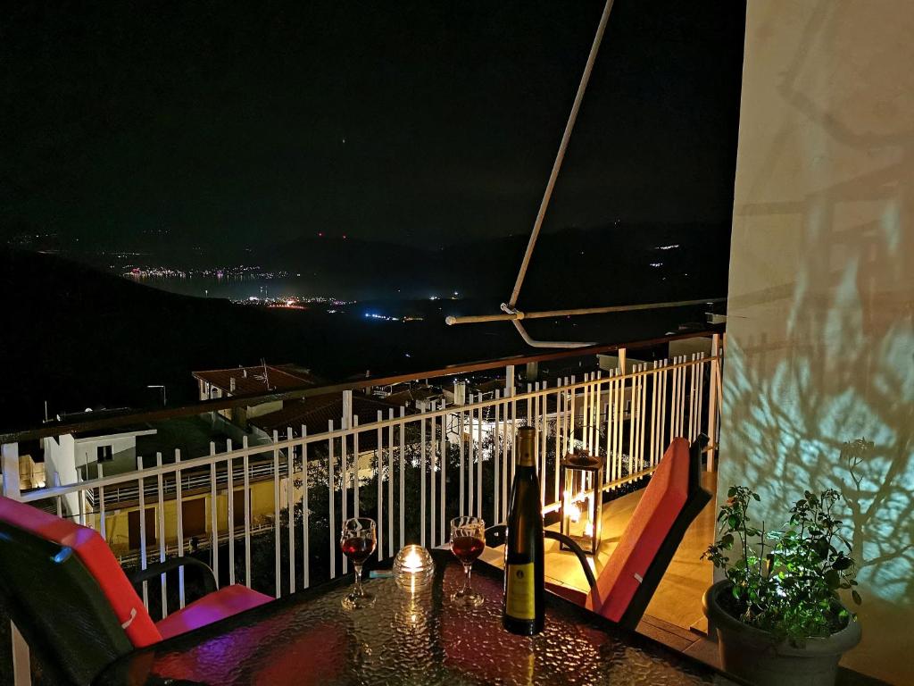 a table with wine bottles on a balcony at night at Delphic Horizons in Delphi