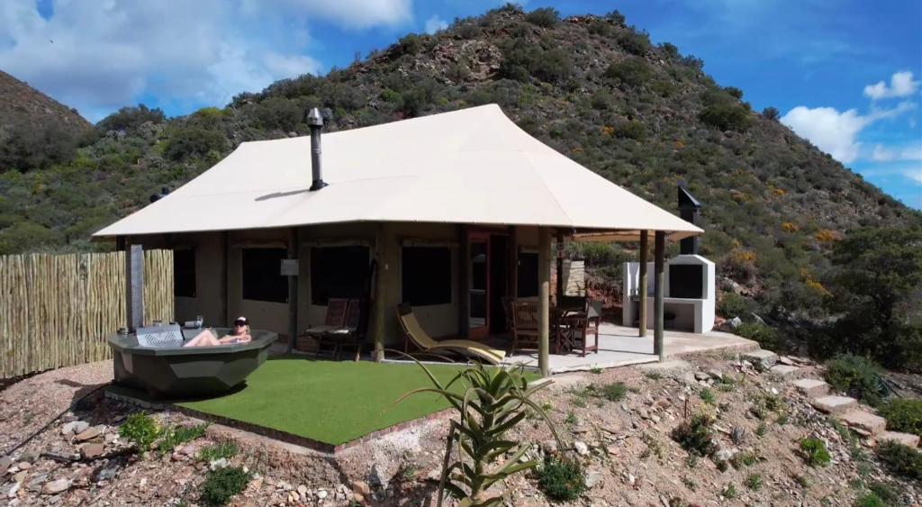 a small house with a gazebo in front of a mountain at Grysbokkloof Private Nature reserve luxury Glamping 6km from Montagu in Montagu