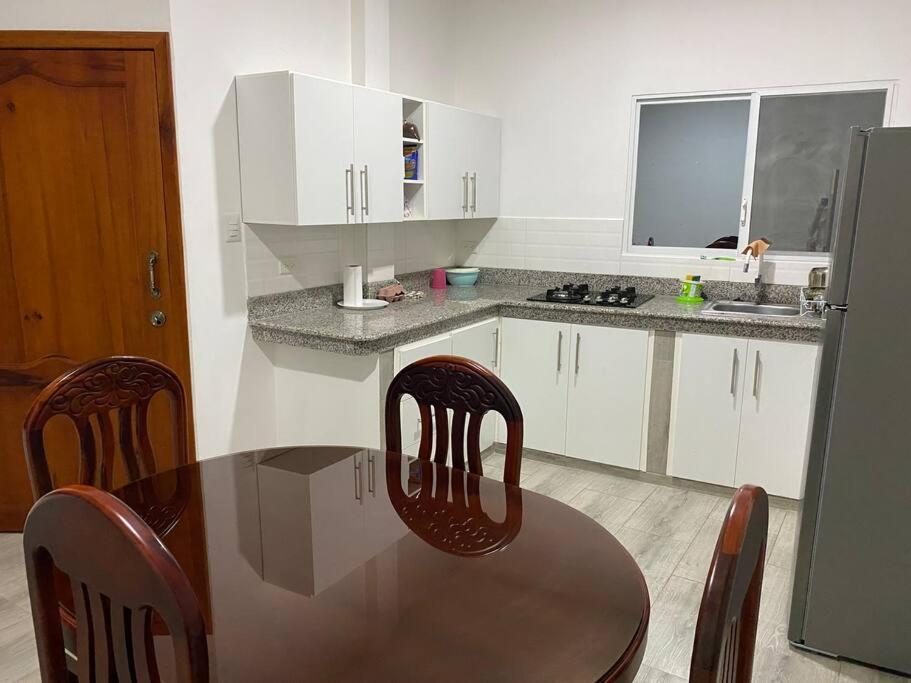 cocina con mesa, 2 sillas y nevera en Suite de lujo totalmente independiente, en Machala