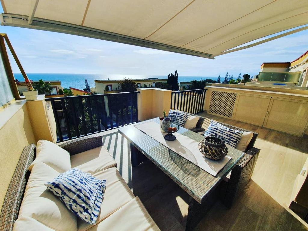 uma varanda com uma mesa e vista para o oceano em Penthouse Haramara, Romana Playa Marbella em Marbella