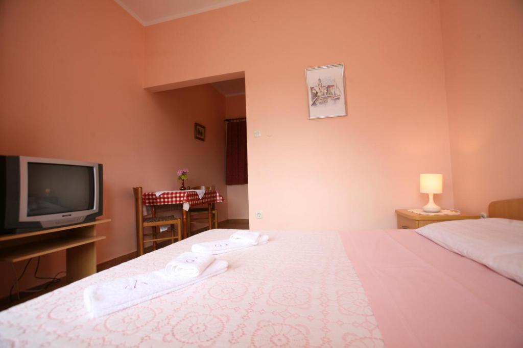 a hotel room with a bed and a tv at Apartments Neda - Poreč South in Poreč