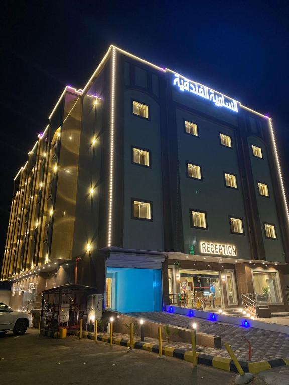 Un edificio de hotel con un cartel en él por la noche. en شقق السامية للشقق المخدومة, en Sharurah