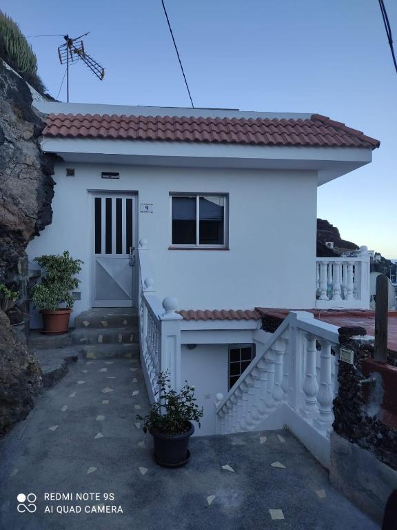 a white house with a staircase in front of it at Apartamento Puerto Estaca 1 in Valverde