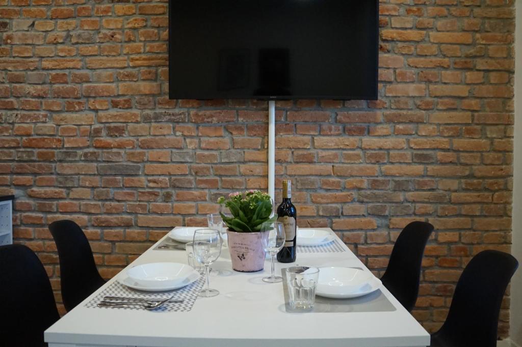 een witte tafel met een fles wijn en een plant erop bij Apartament Gliwice Centrum Witkiewicza II in Gliwice