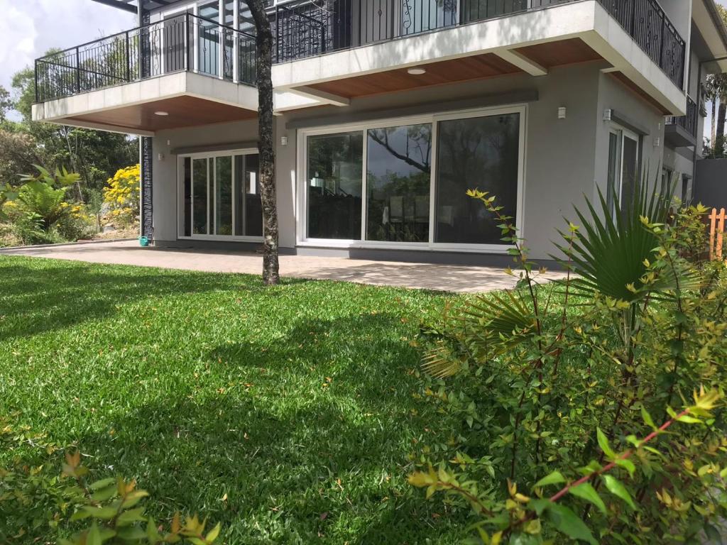 une maison avec une pelouse verte devant elle dans l'établissement Belvedere Gramado, à Gramado