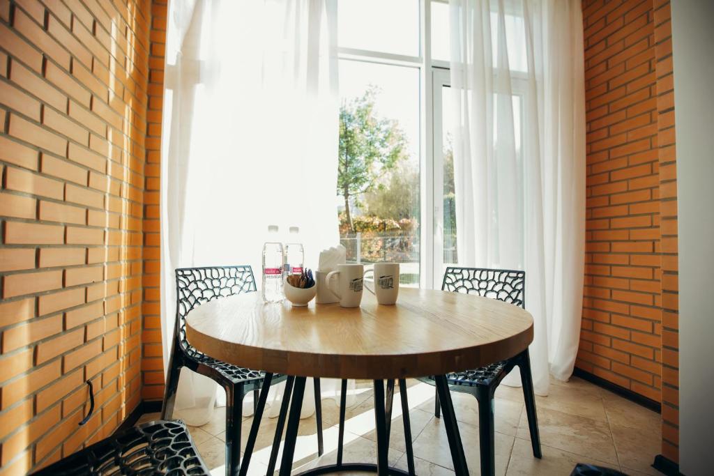 mesa y sillas en una habitación con ventana en Vodogray apartments, en Chernivtsi