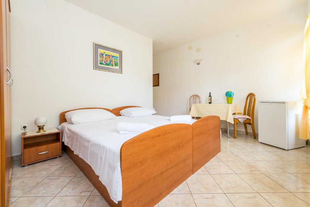 a bedroom with a large bed and a table at AVA Studio apartment and Room in Dubrovnik