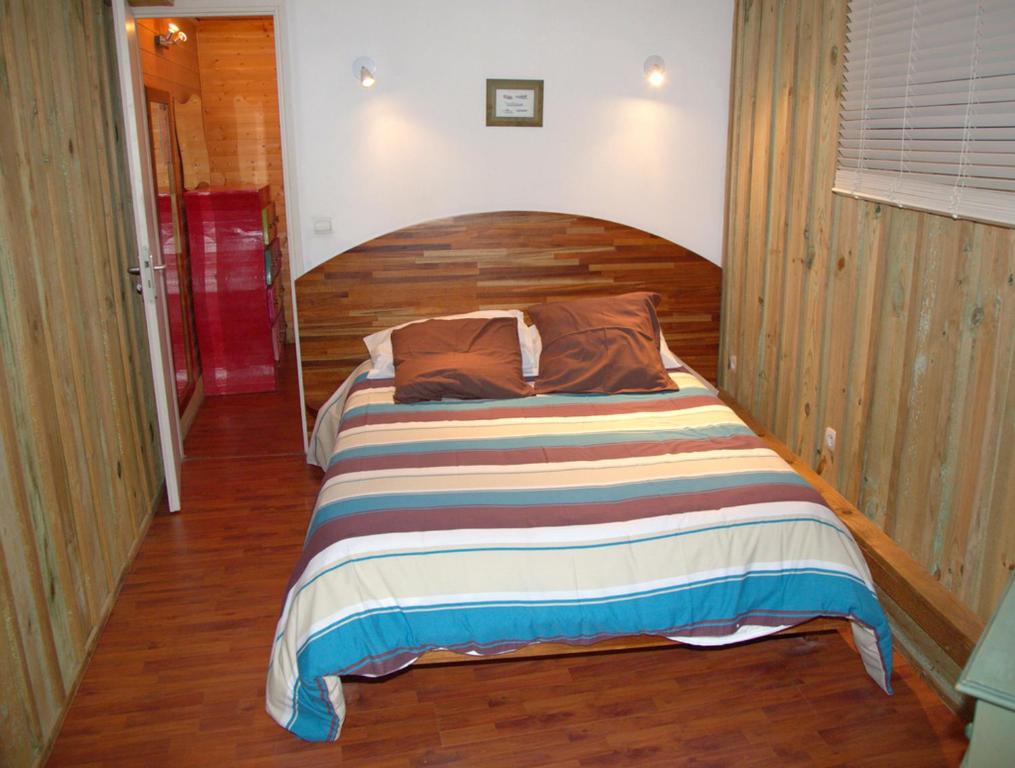 a bed with a wooden headboard in a bedroom at Hotel du Cap in Cap-Ferret