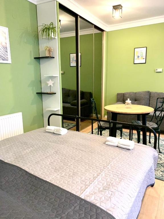 een slaapkamer met een bed, een tafel en een bank bij Fidelissima Apartman in Sopron