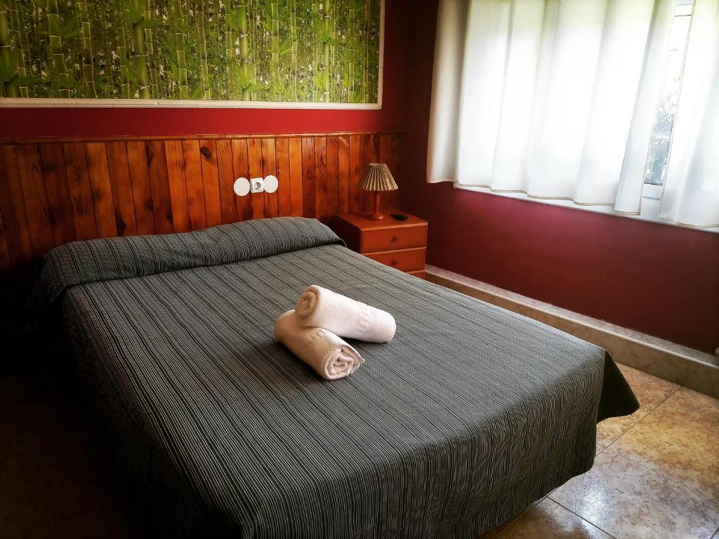 una cama con un animal de peluche sentado encima en Hostal Isla Cristina Mataro, en Mataró