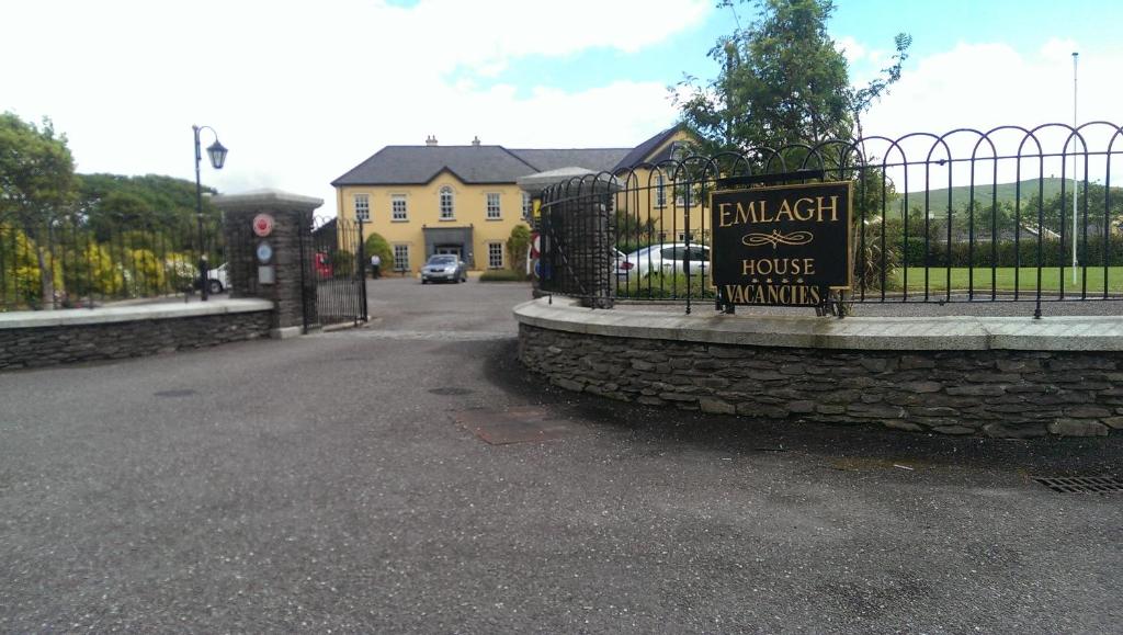 a fence with a sign in front of a house at Emlagh House in Dingle