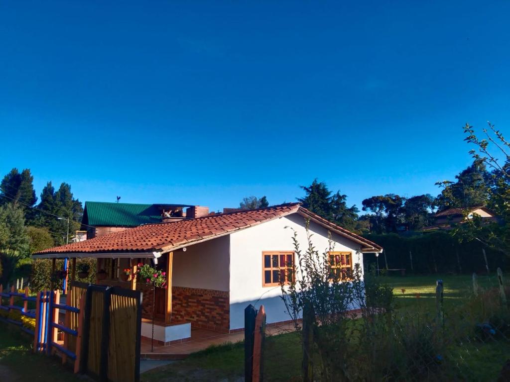 uma casa branca com uma cerca na frente em Samaria, un lugar para descansar y disfrutar em Santa Elena