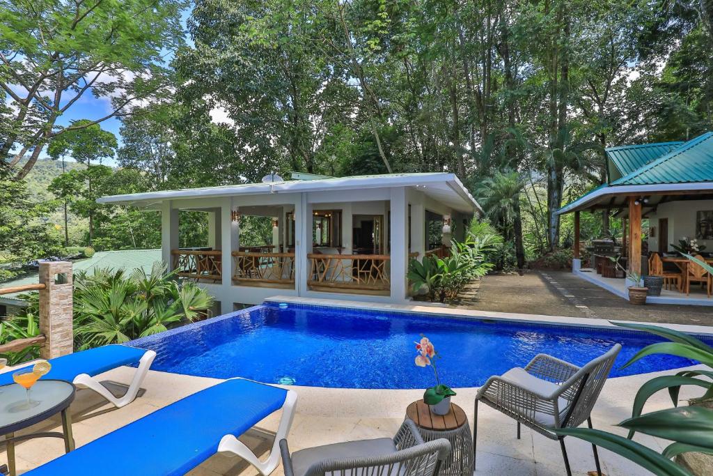 a swimming pool in a backyard with a house at Casa de Paz- Portasol Vacation Rentals in Matapalo