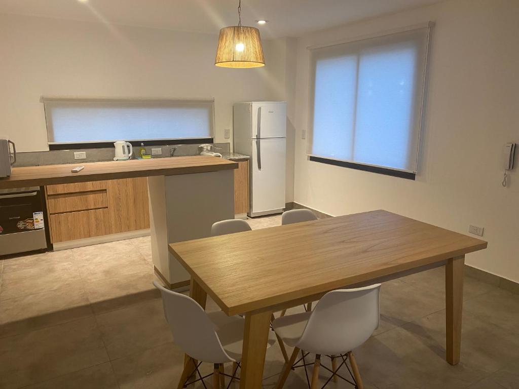 a kitchen with a wooden table and white chairs at La Escondida Salta 5 in Salta