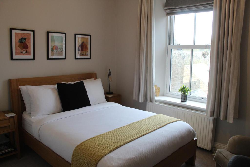 een slaapkamer met een groot bed en een raam bij The Hill B&B in Middleton in Teesdale