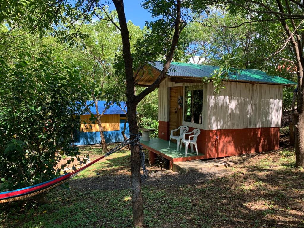 une petite maison avec un hamac en face de celle-ci dans l'établissement Cabañas Casa Soley, à Puerto Soley